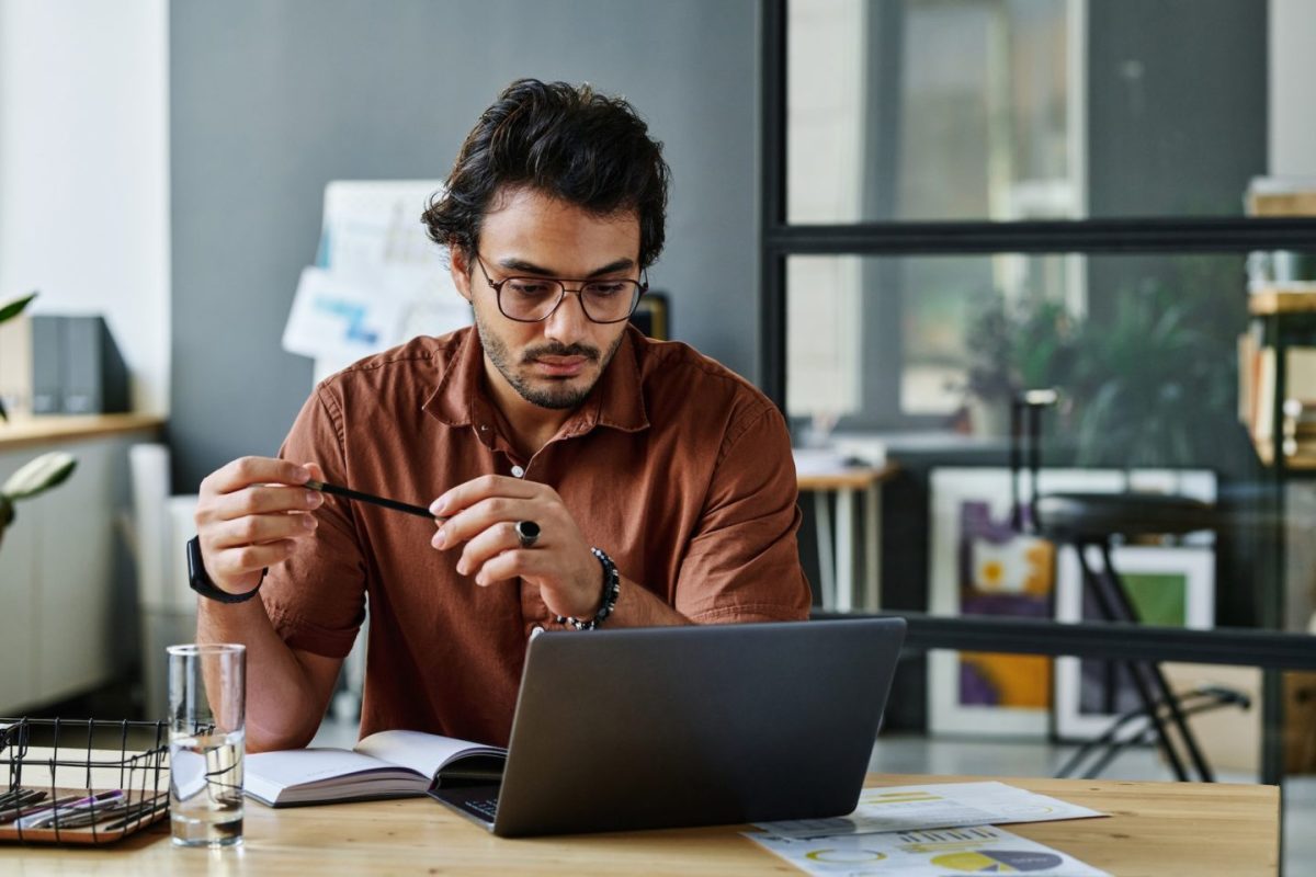 young-serious-businessman-in-shirt-and-eyeglasses-networking-e1701763577486